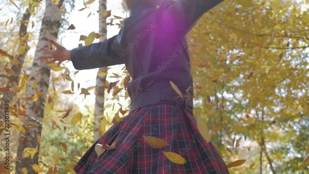 Adorable happy school girl throwing the fallen leaves up, playing in the autumn forest. Beautiful girl having fun in autumn park. Slow motion. Adorable happy school girl throwing the fallen leaves up, playing in the autumn forest. Beautiful girl having fun in autumn park. Slow motion.