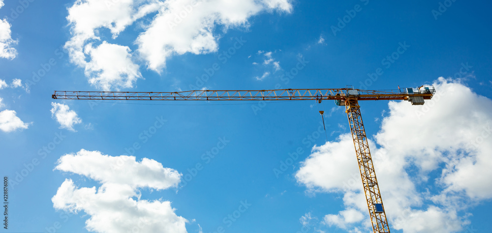 Yellow tower crane on blue sky background Yellow tower crane on blue sky background