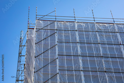 Building construction with scaffolding, blue sky background photo
