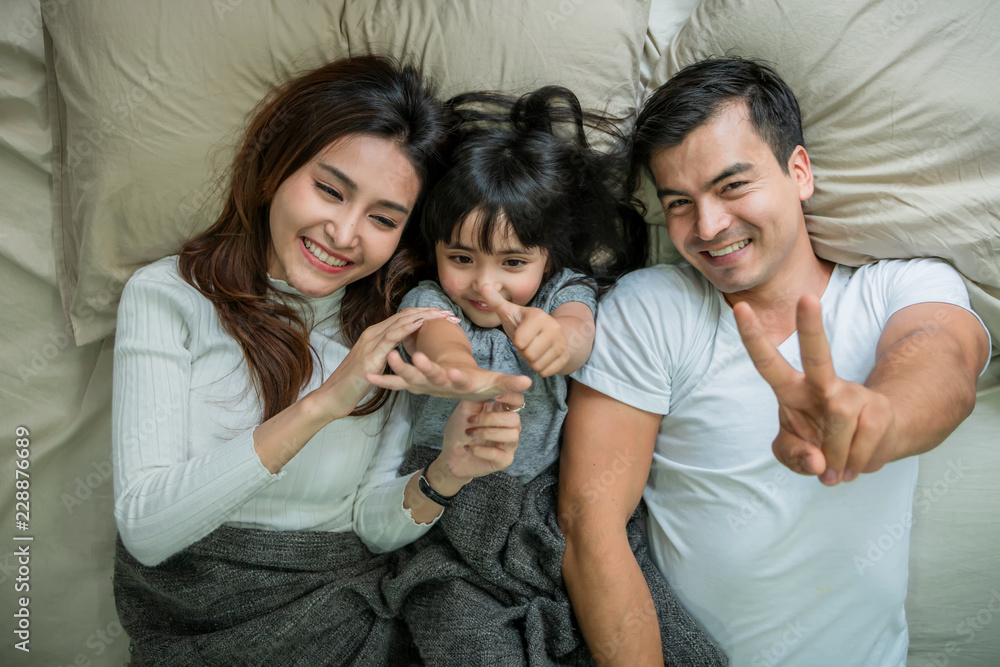 lovely moment family concept with daughter and parent playing together in blanket on soft bed morning time