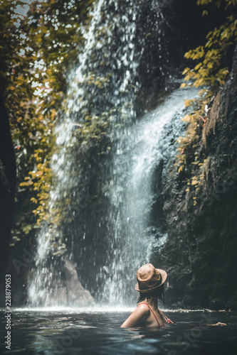 Fototapeta Naklejka Na Ścianę i Meble -  Young woman tourist in the deep jungle with waterfall. Real adventure concept. Bali island.