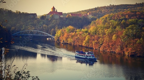 Castle Veveri - City of Brno, Czech Republic - Europe. Beautiful autumn landscape with castle. Brno dam with boat and sunset at the golden hour. Autumn season October.