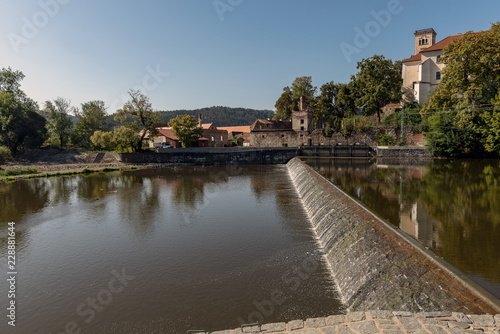 sun-lit weirs on the river Sazava in the background of the Sázava monastery building © Vladimira