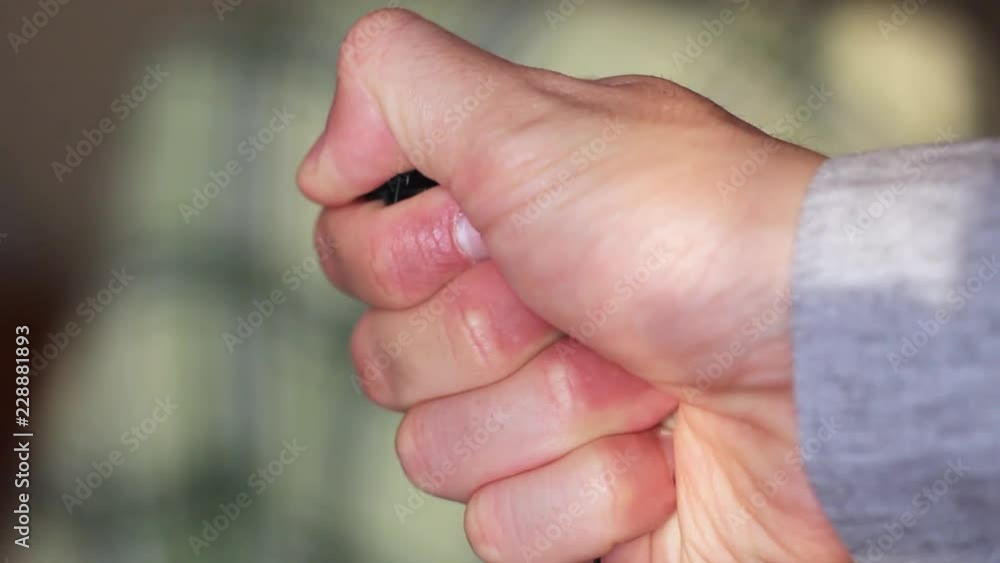 small black wooden cross in male hand small black wooden cross in male hand