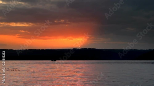 beautiful sunset over the water and fishers boat silhouette. Bakota bay (Dnistrovske reservoir), Dnister river, Podilski tovtry National park, Khmelnitskiy region of Western Ukraine photo