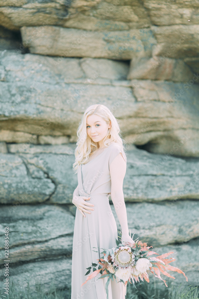 Weddings in the mountains by the rocks. The ceremony in the style of fine art. Summer walking photo shoot of newlyweds.