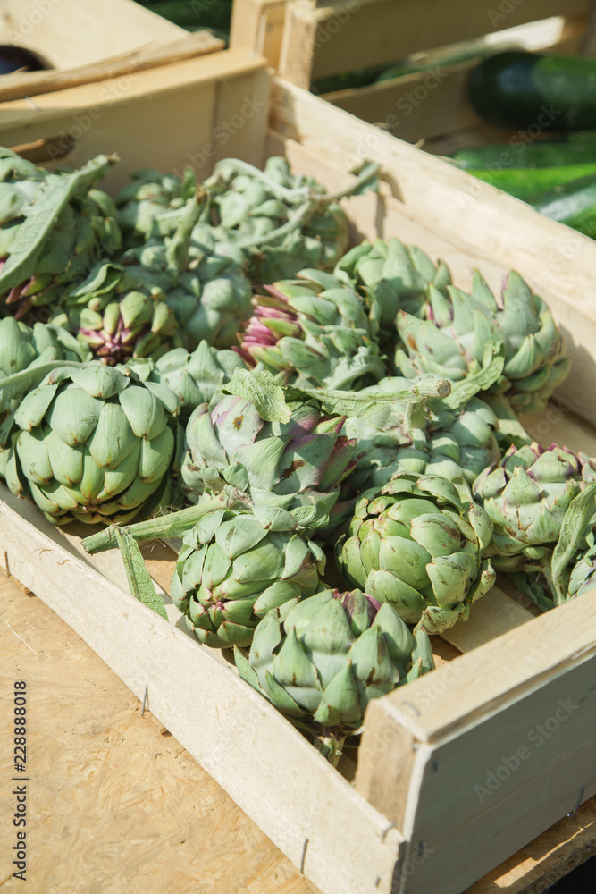 Fresh artichokes on sale in wooden boxes at the french city market Fresh artichokes on sale in wooden boxes at the french city market