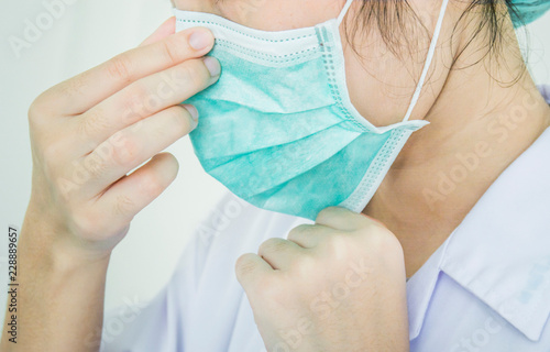 The doctor is wearing or removing the mask