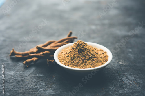 Ashwagandha / Aswaganda OR Indian Ginseng is an Ayurveda medicine in stem and powder form. Isolated on plain background. selective focus photo