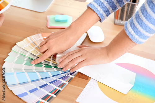 Designer with paint color palette samples at table, closeup