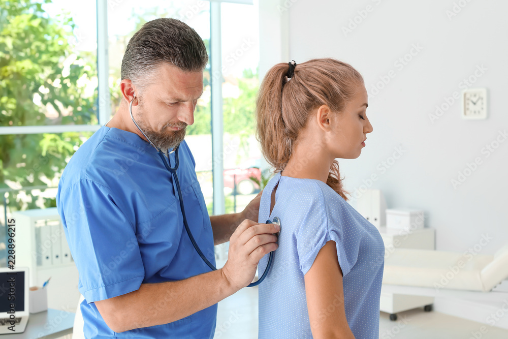 Obraz premium Male medical assistant examining female patient in clinic