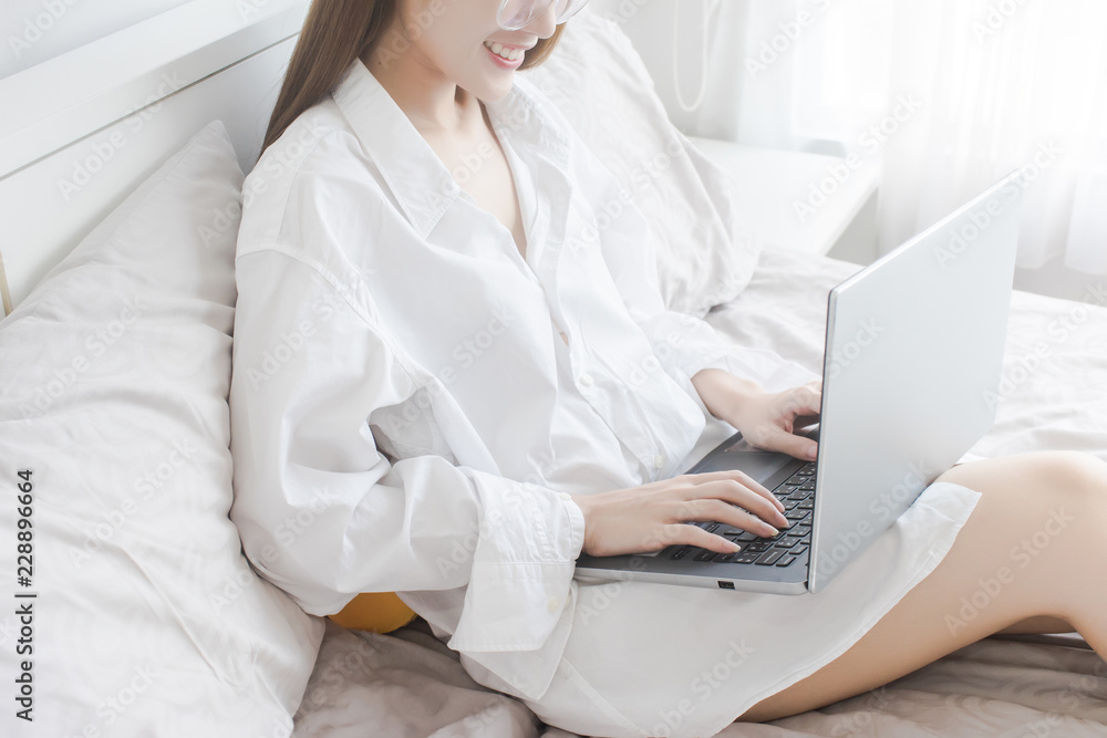 Sexy Asian Woman use of laptop computer for online shopping on bed Sexy Asian Woman use of laptop computer for online shopping on bed
