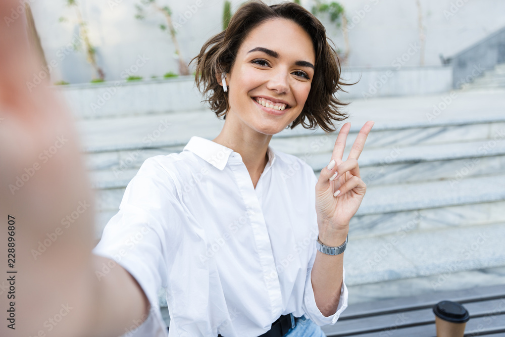 Attractive young woman in earphones standing Attractive young woman in earphones standing