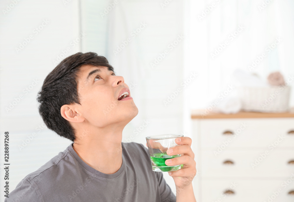 Man rinsing mouth with mouthwash in bathroom. Teeth care Man rinsing mouth with mouthwash in bathroom. Teeth care