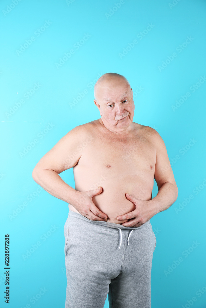 Fat senior man on color background. Weight loss