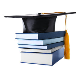 Graduation hat with gold tassel and stack of books isolated on white