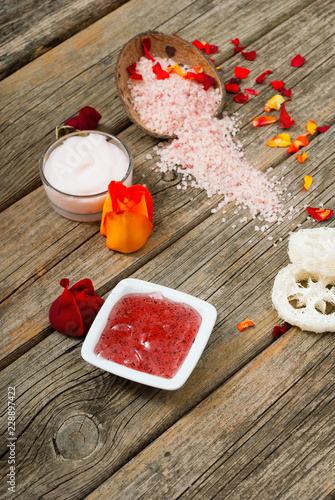 facial mask and moisturizer with roses on weathered wooden