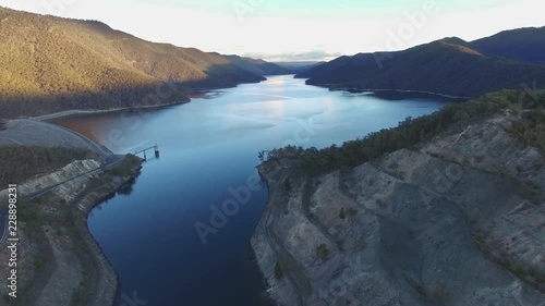 Forward flight over river towards beautiful lake in the mountains at sunset. New South Wales, Australia photo