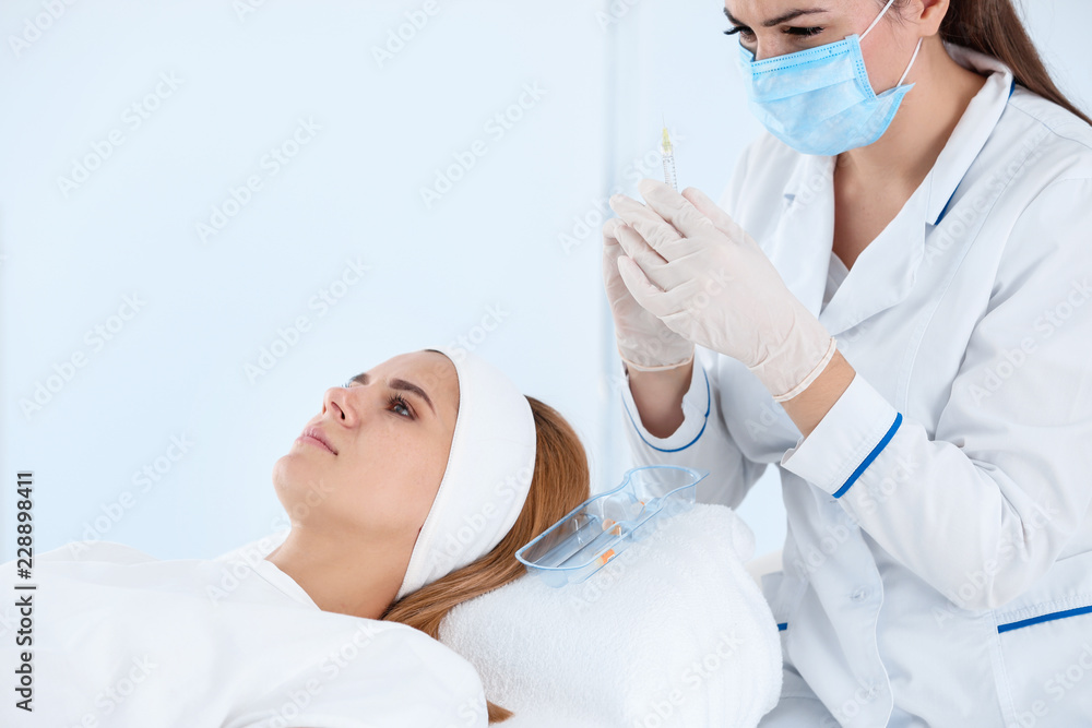 Woman undergoing face biorevitalization procedure in salon. Cosmetic treatment Woman undergoing face biorevitalization procedure in salon. Cosmetic treatment