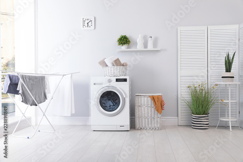 Laundry room interior with washing machine near wall