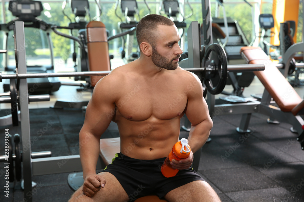 Naklejka premium Portrait of athletic man with protein shake in gym