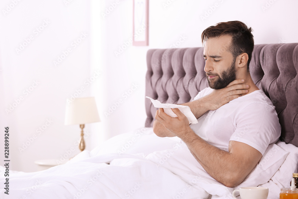 Ill man suffering from cough in bed. Space for text Ill man suffering from cough in bed. Space for text