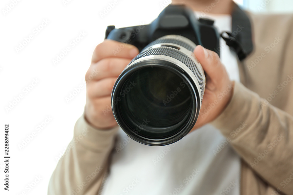 Male photographer with professional camera on white background, closeup