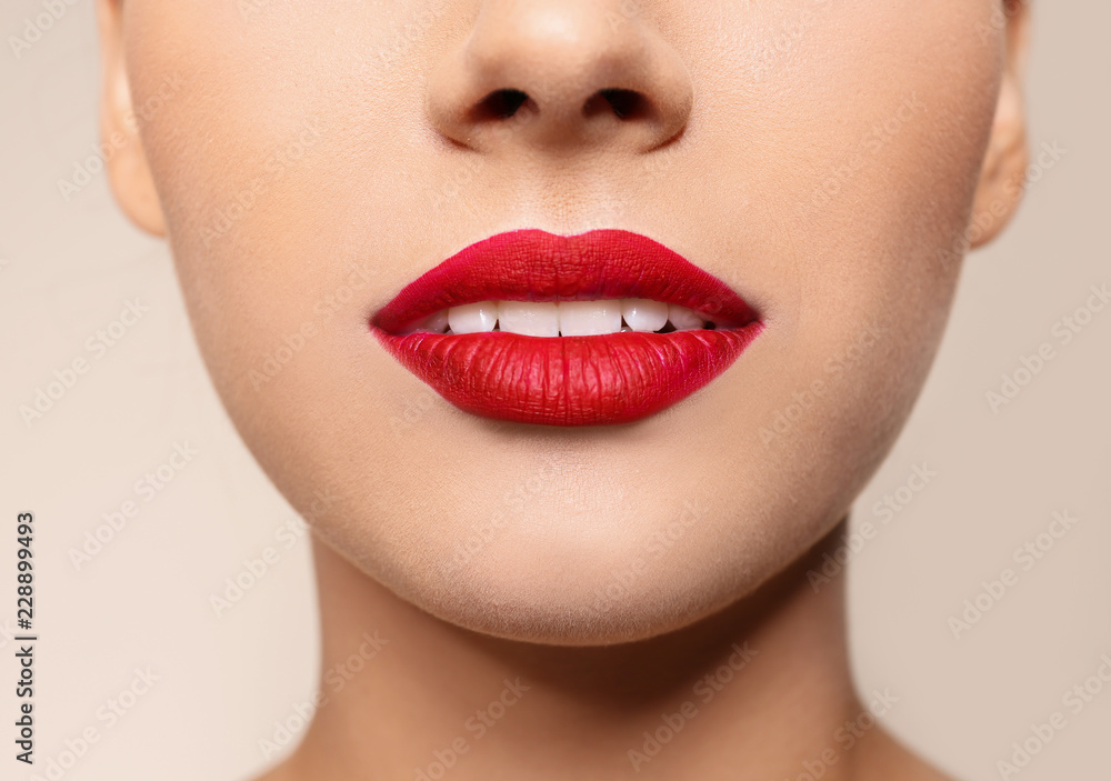 Fototapeta premium Beautiful young woman with red lips on color background, closeup