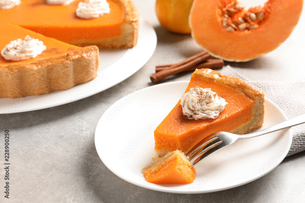 Plate with piece of fresh delicious homemade pumpkin pie on light table Plate with piece of fresh delicious homemade pumpkin pie on light table