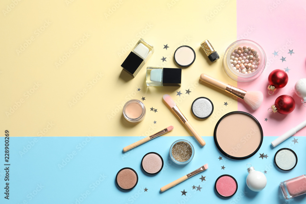 Fototapeta Flat lay composition with makeup products and Christmas decor on color background. Space for text