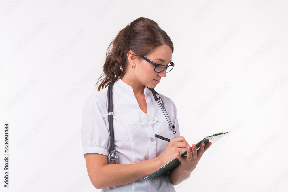 Female medicine doctor hand holding pen writing something on clipboard on white background. Female medicine doctor hand holding pen writing something on clipboard on white background.