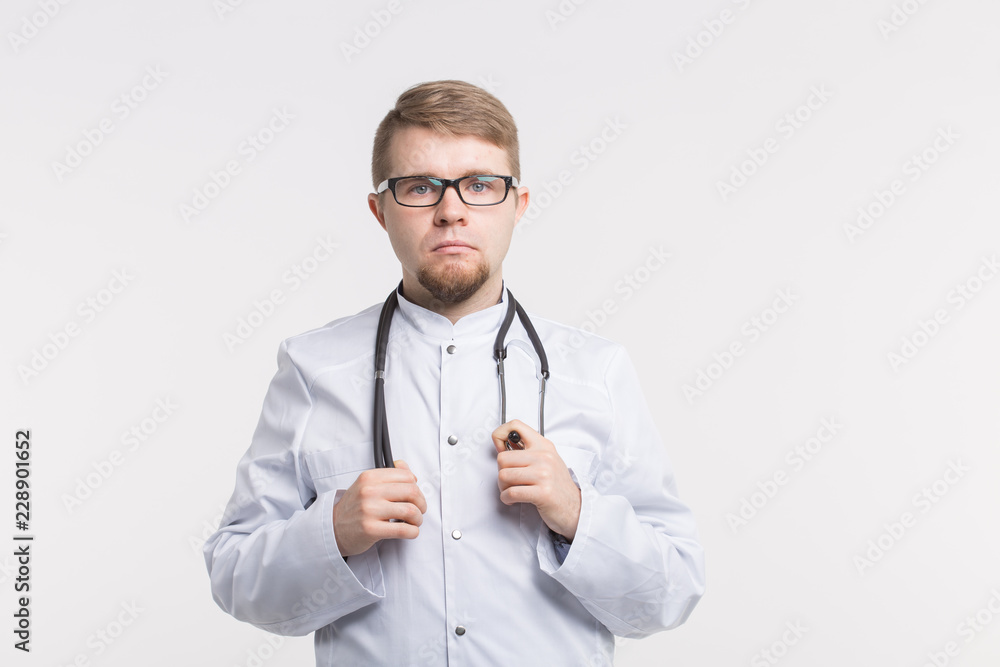 Serious male doctor standing on white background. Medical concept. Serious male doctor standing on white background. Medical concept.