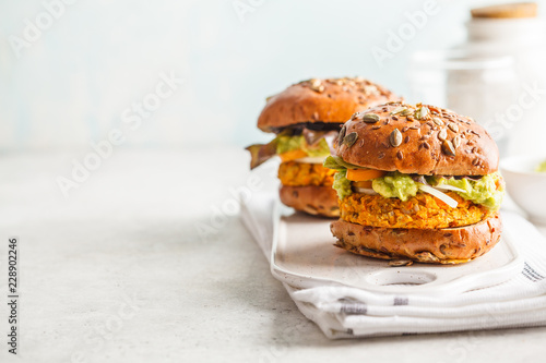 Vegan sweet potato (or pumpkin) burgers on white background. Vegetable burgers, avocado, vegetables and buns, copy space.
