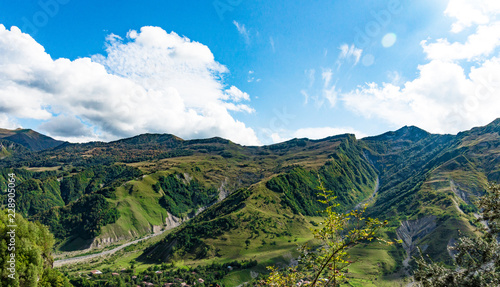 Mountain hill path road panoramic landscape, clouds in the blue sky, summer sunny day