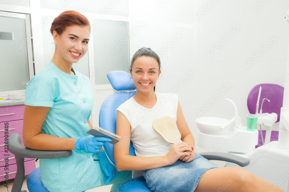 Beautiful female patient with dental treatment in the dentist office. A woman visiting her dentist. Women look into the camera Beautiful female patient with dental treatment in the dentist office. A woman visiting her dentist. Women look into the camera
