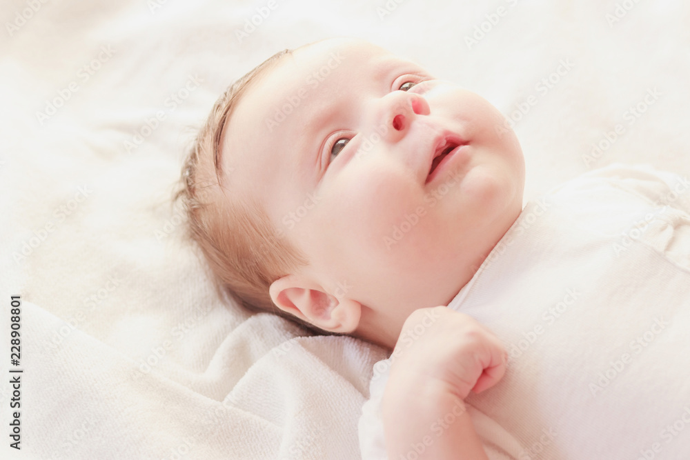 Smiling baby on the bed, soft focus background Smiling baby on the bed, soft focus background