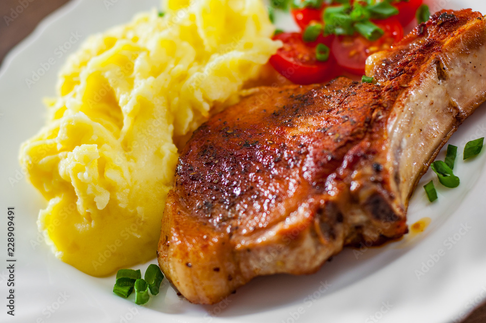 Grilled pork loin meat with mashed potatoes and salad in white plate Grilled pork loin meat with mashed potatoes and salad in white plate