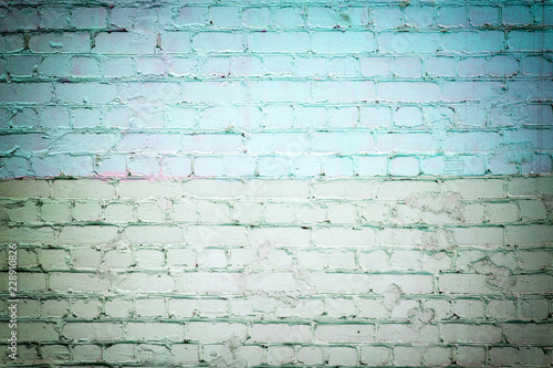 Brick wall painted with green and turquoise paint. Background with brickwork texture.