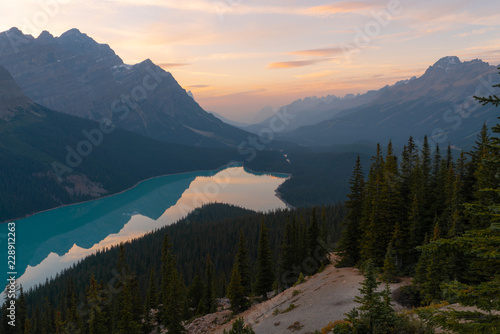 The orange glow of sunset over Peyto Lake in Banff National Park on a partly cloudy day © Jesse