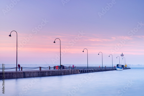 morning silence above pier with street lighters and smooth water in the sea