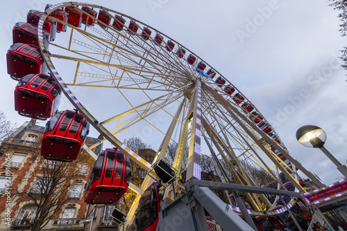 Wheel coaster with red cabins in Reims city center, France