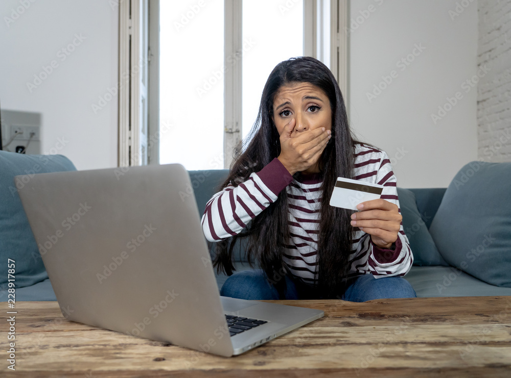 Young woman using laptop angry and stressed about her credit card bill Young woman using laptop angry and stressed about her credit card bill