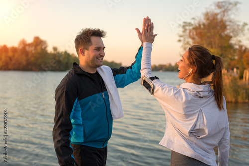Happy young couple high fiving after workout outside