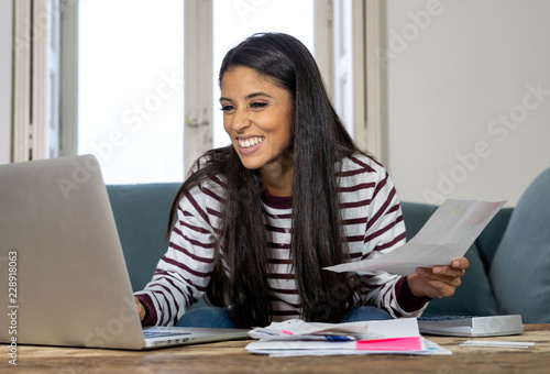 Fotografía Cheerful beautiful woman paying bills online and managing budget feeling happy a