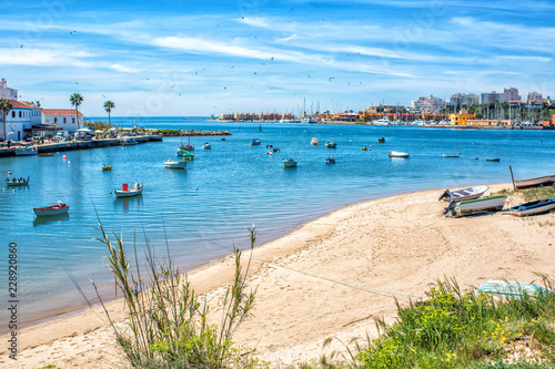 View on the Ferragudo and Portimao Algarve across the river and many fishing boats in the foreground photo