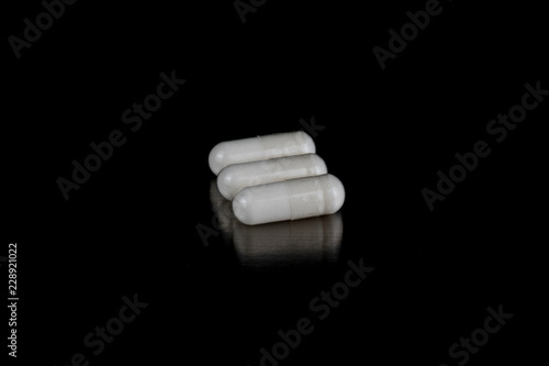 Obraz na płótnie White Capsules on Black w salonie
