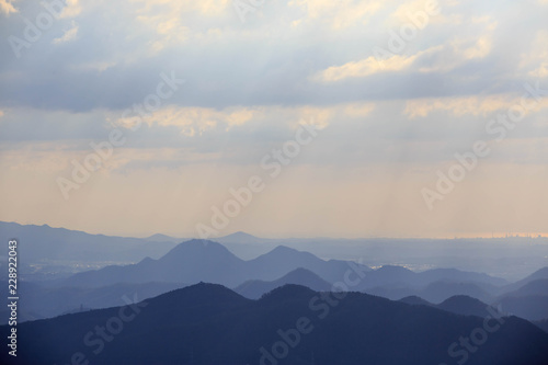 Sun rays shine on distant blue mountains
