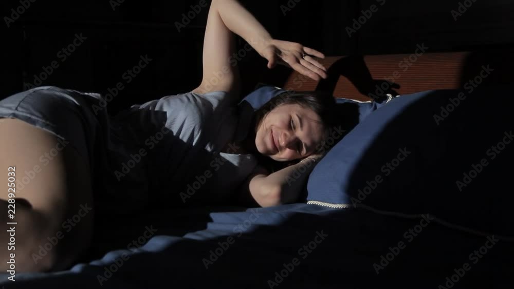 Young girl sleeping on the bed and smiling wakes up Young girl sleeping on the bed and smiling wakes up