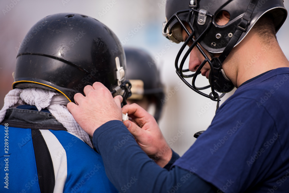Fototapeta premium American football players checking helmets