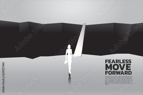 silhouette of businesswomen with briefcase step forward to cross abyss. concept of business challenge and courage women